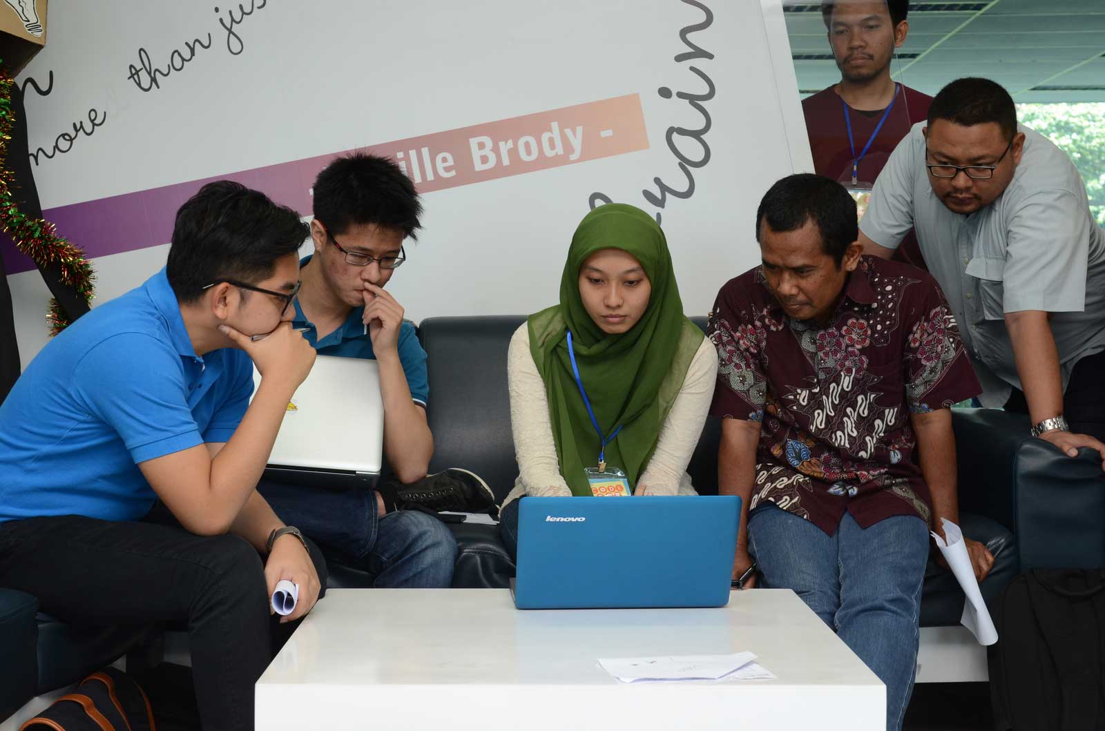 group of Asians looking at laptop screen